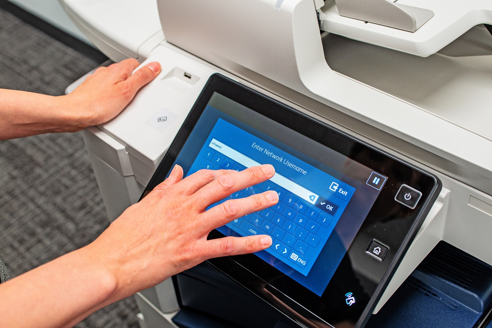 Person logging in on a multifunction printer’s user interface.